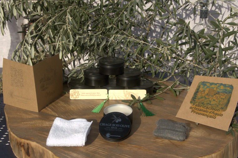 Thumbnail of Mise en scène provençale du kit cire bois : pot et accessoires sur table rustique avec lavande, olive et tissu en lin au soleil couchant